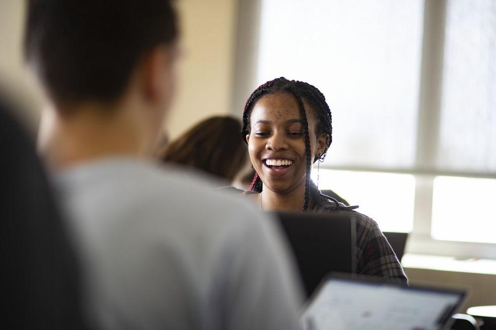 A Temple student laughs along with her peers during class discussion.
