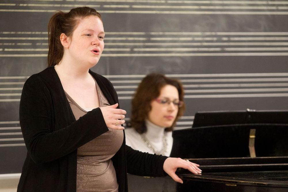 A Boyer College of Music and Dance student sings while a woman plays the piano.